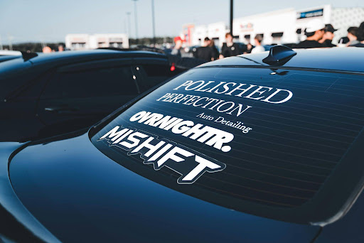 White-lettering decal on a vehicle window promoting polished-perfection detailing. 